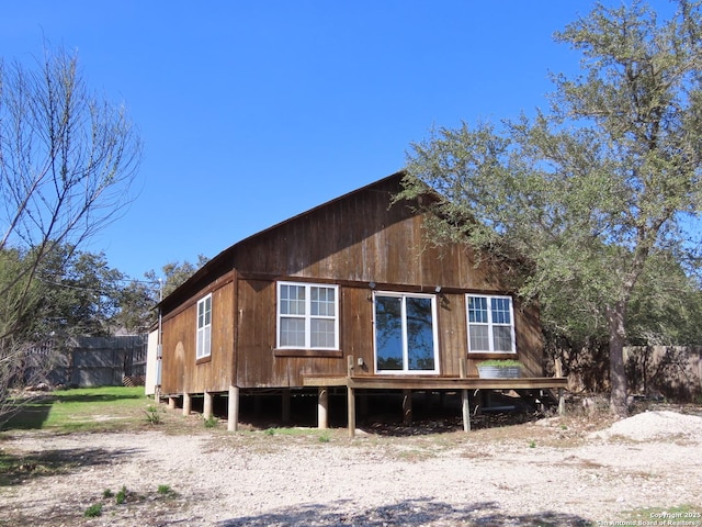 rear view of house featuring fence