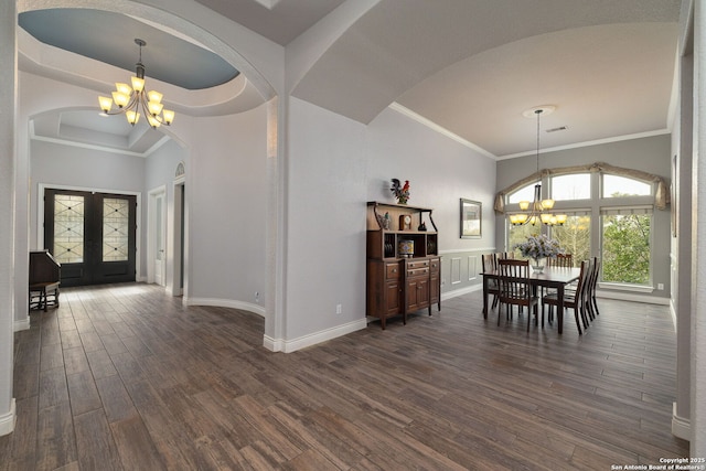 unfurnished dining area with a chandelier, french doors, ornamental molding, and dark wood-style flooring