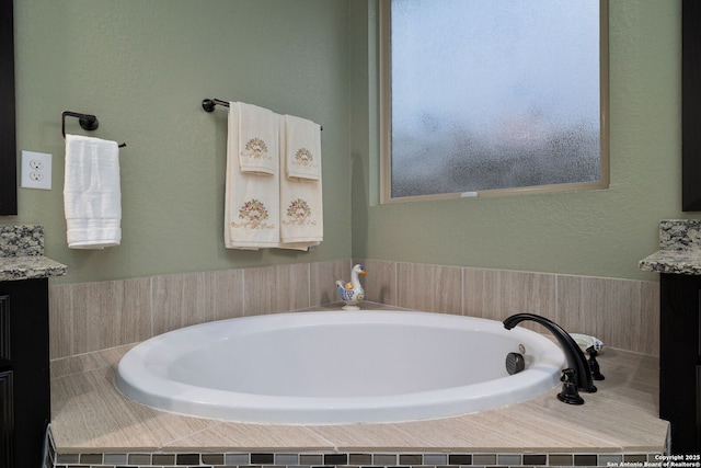 bathroom with a garden tub and vanity