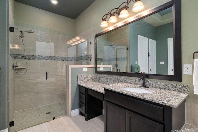 full bath with a stall shower and vanity