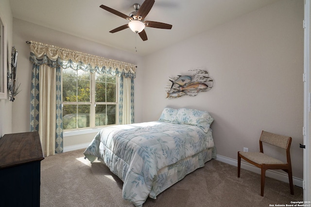 carpeted bedroom with ceiling fan and baseboards