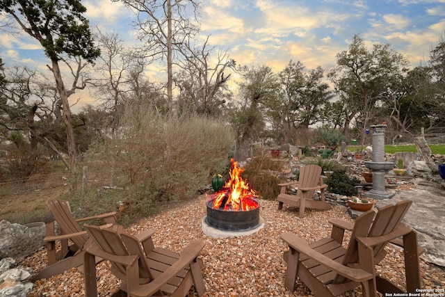 patio terrace at dusk featuring a fire pit