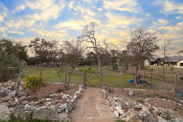 yard at dusk with a gate and fence