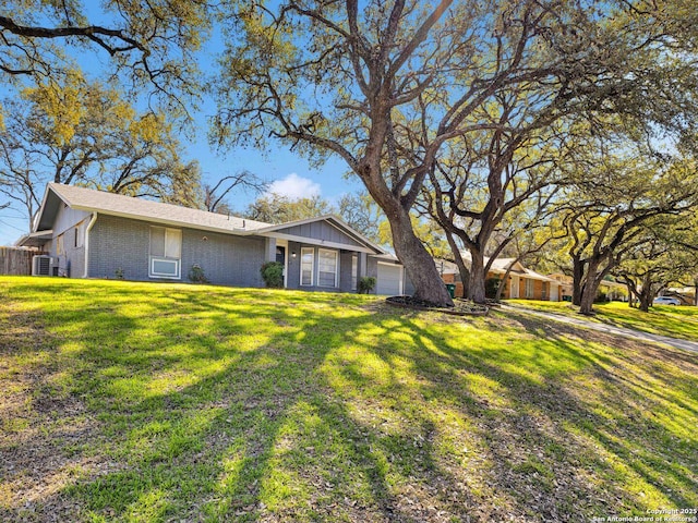 ranch-style house with an attached garage, brick siding, and a front yard