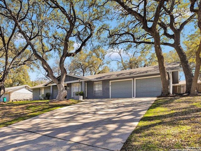 view of front of property with concrete driveway, brick siding, a front lawn, and an attached garage