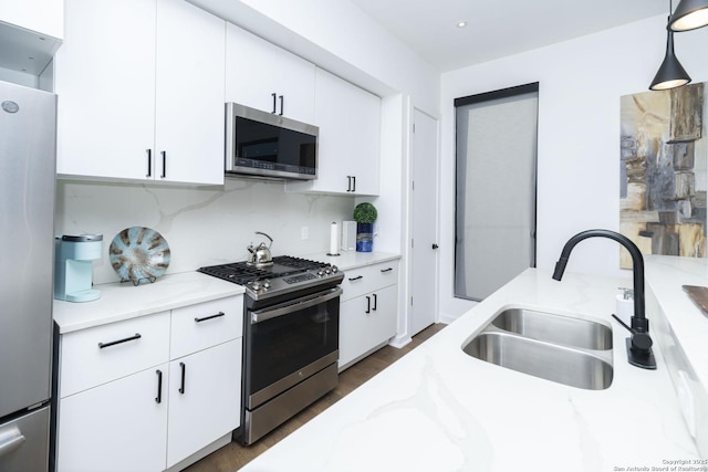 306 S Mesquite St, San Antonio, TX 78203 - kitchen featuring tasteful backsplash, appliances with stainless steel finishes, light stone countertops, white cabinetry, and a sink
