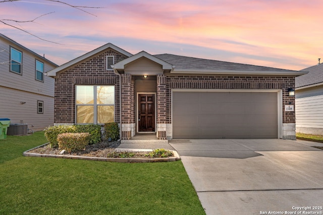 ranch-style home with brick siding, central air condition unit, a lawn, a garage, and driveway