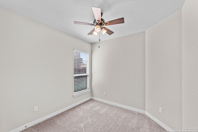 empty room with ceiling fan, a textured ceiling, carpet flooring, and baseboards