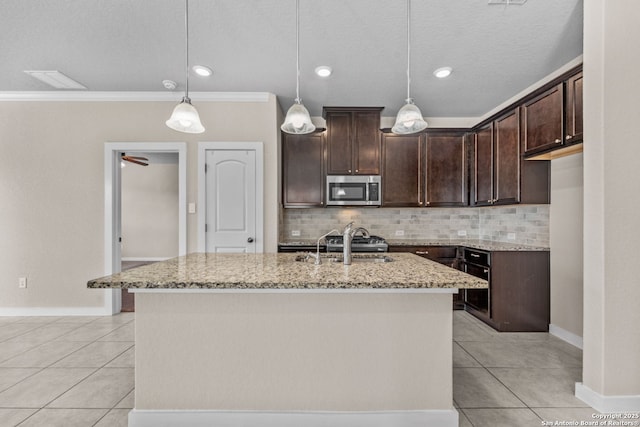 kitchen featuring light stone counters, stainless steel microwave, dark brown cabinets, and light tile patterned floors