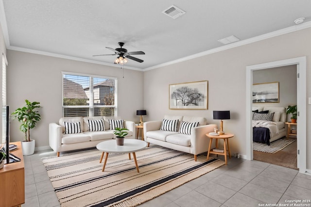 living area featuring light tile patterned floors, ceiling fan, visible vents, baseboards, and ornamental molding