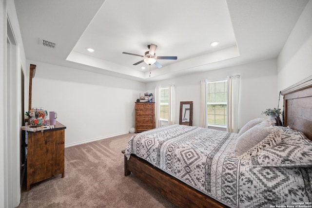 bedroom featuring carpet, a tray ceiling, baseboards, and recessed lighting