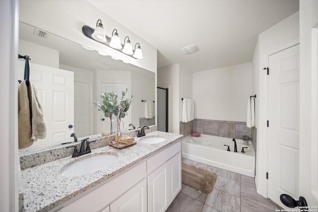 full bathroom with double vanity, a sink, and a bath