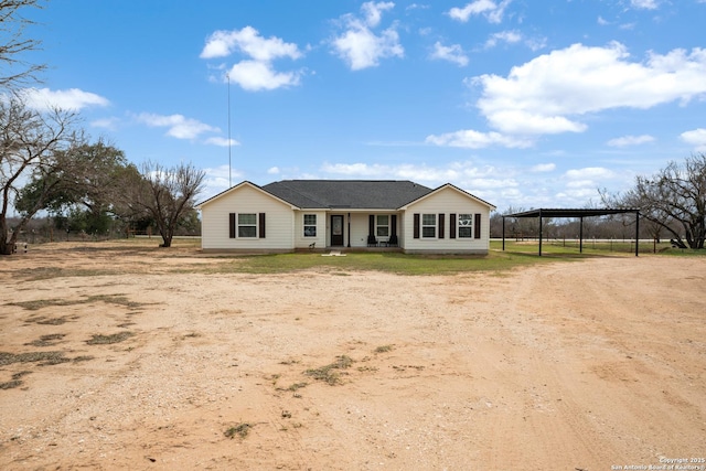 view of front of house featuring dirt driveway and a detached carport