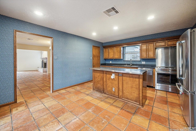 kitchen featuring wallpapered walls, visible vents, brown cabinetry, stainless steel appliances, and recessed lighting