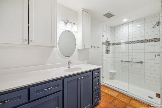 full bath with tile patterned floors, a shower stall, visible vents, and vanity