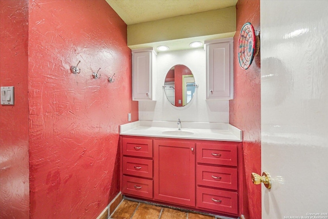 bathroom featuring a textured wall and vanity