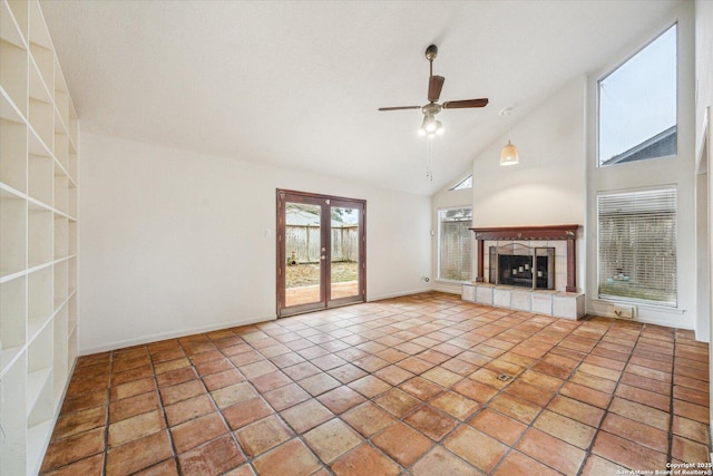 unfurnished living room with french doors, a fireplace, a ceiling fan, high vaulted ceiling, and tile patterned floors