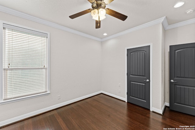 unfurnished bedroom with a ceiling fan, crown molding, baseboards, and dark wood-style flooring