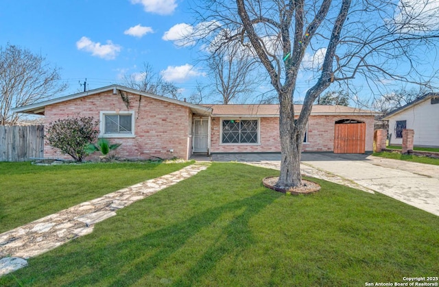 ranch-style home with driveway, a front yard, and brick siding