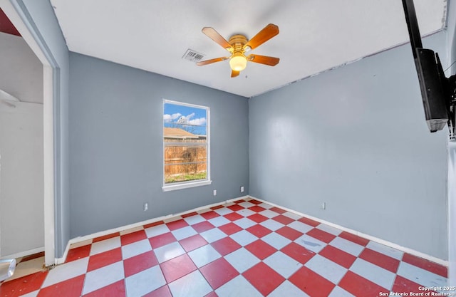 unfurnished room with a ceiling fan, visible vents, baseboards, and tile patterned floors