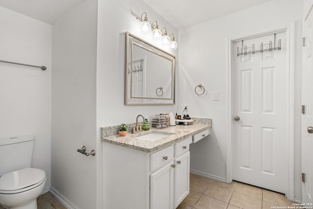 bathroom with baseboards, vanity, toilet, and tile patterned floors