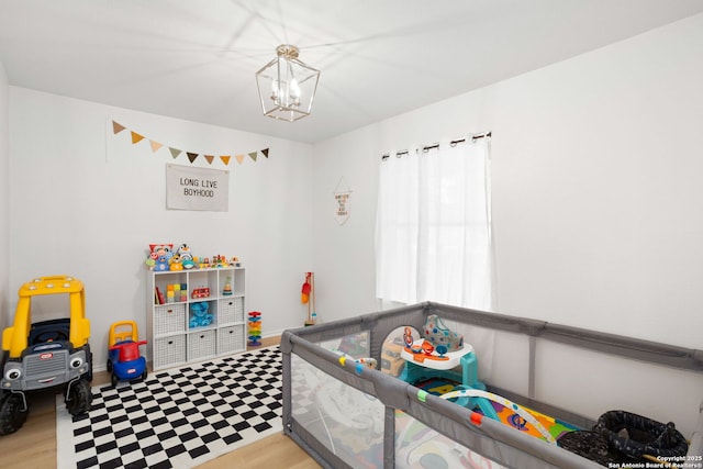 bedroom featuring a notable chandelier, baseboards, and wood finished floors