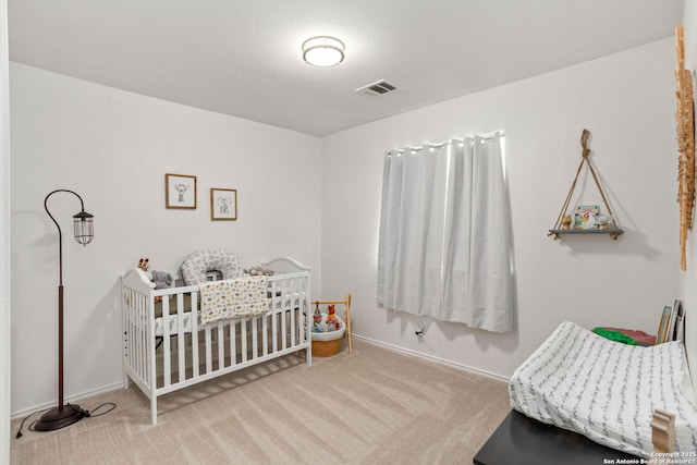 bedroom featuring carpet, visible vents, and a textured ceiling