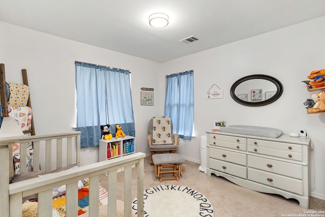 carpeted bedroom featuring a nursery area and visible vents