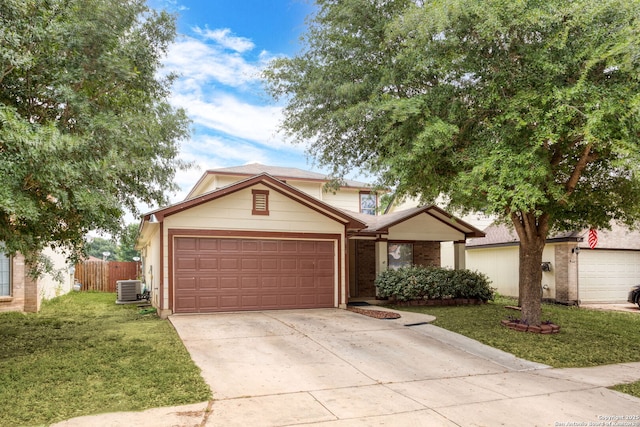 traditional-style house with an attached garage, fence, cooling unit, driveway, and a front lawn