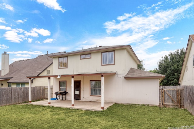 back of house with a fenced backyard, a lawn, and a patio