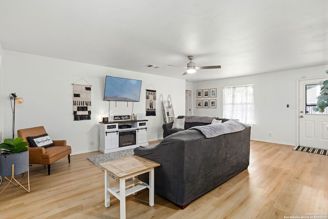 living area with baseboards, visible vents, and light wood finished floors