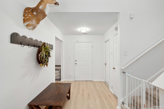 interior space with baseboards, visible vents, stairway, and light wood finished floors