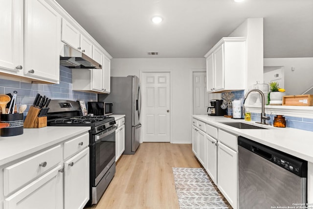 kitchen featuring appliances with stainless steel finishes, white cabinetry, visible vents, and under cabinet range hood