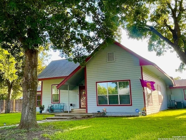 view of front facade with central AC, a porch, a front yard, and fence