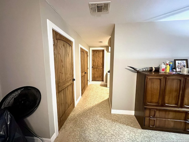 corridor featuring visible vents and baseboards