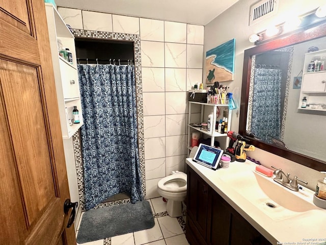 full bath with visible vents, toilet, vanity, a shower stall, and tile walls