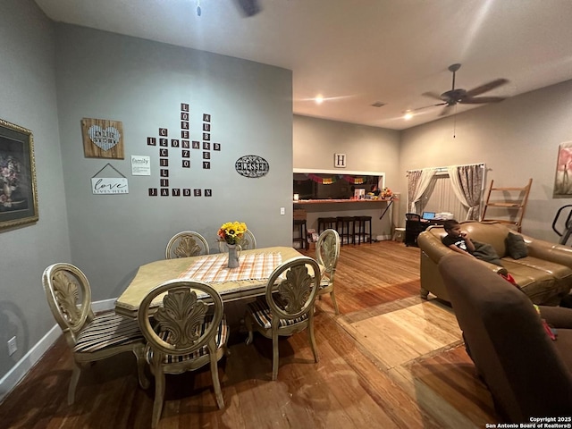 dining space featuring ceiling fan, baseboards, and wood finished floors