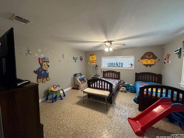 bedroom featuring a textured ceiling, ceiling fan, visible vents, and baseboards