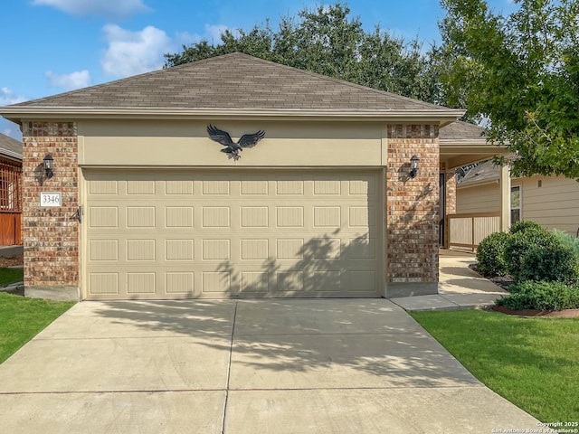 view of front facade featuring concrete driveway, brick siding, an attached garage, and stucco siding