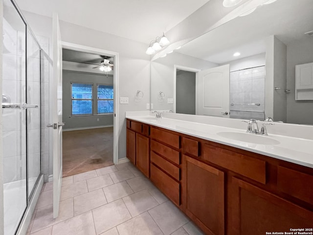 bathroom featuring double vanity, a stall shower, a sink, and tile patterned floors