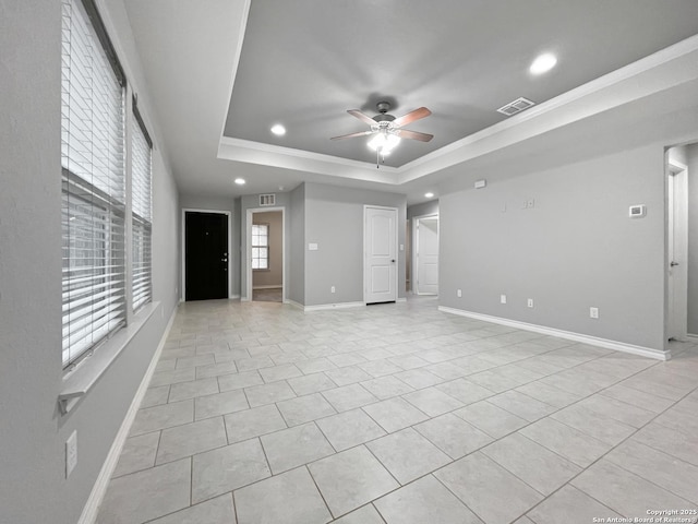 unfurnished living room featuring light tile patterned floors, a ceiling fan, visible vents, baseboards, and a tray ceiling