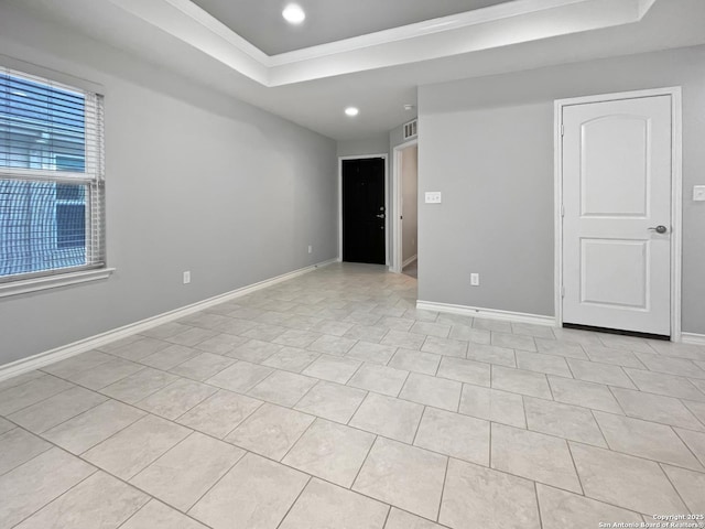 empty room with baseboards, a raised ceiling, and recessed lighting