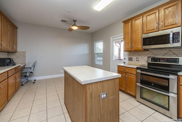 kitchen featuring a kitchen island, visible vents, stainless steel appliances, and light tile patterned flooring