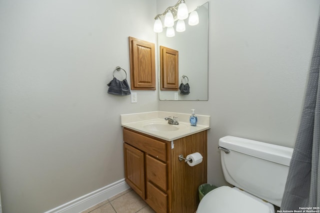 bathroom featuring toilet, tile patterned flooring, baseboards, and vanity