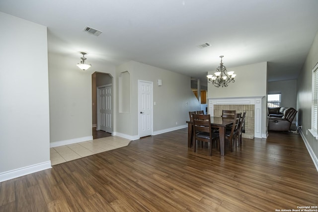 dining area with visible vents, a notable chandelier, and wood finished floors