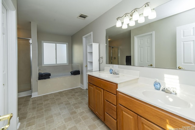 full bath with double vanity, a shower stall, visible vents, and a sink