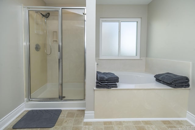 full bath with a shower stall, baseboards, and a bath