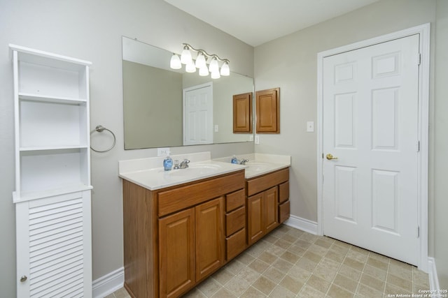 bathroom with double vanity, a sink, and baseboards