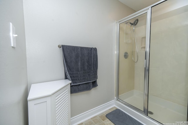 bathroom featuring a shower stall and baseboards