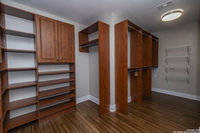 walk in closet featuring visible vents and dark wood finished floors